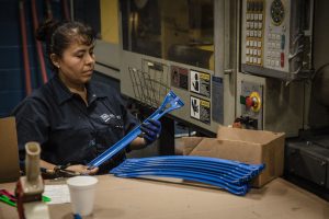 Employee checks product for injection molding errors